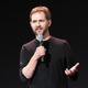 WandaVision director Matt Shakman holds a microphone onstage at a Disney event.